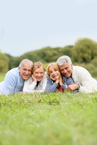 Senior mensen leggen in gras — Stockfoto