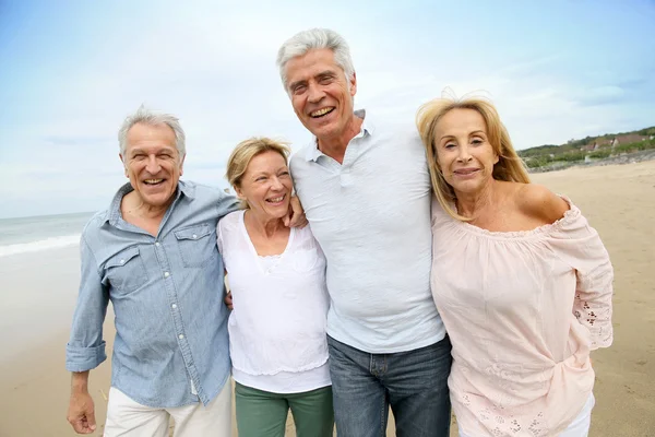 Senioren spazieren am Strand — Stockfoto