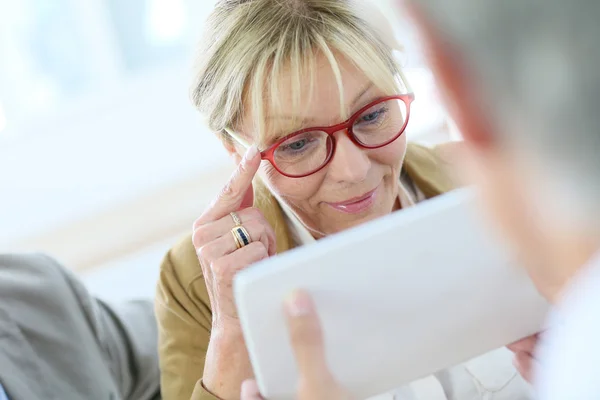 Senior woman trying  eyeglasses on — Stock Photo, Image