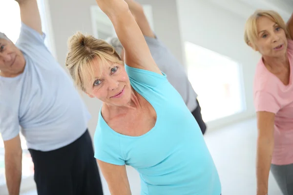 Människor sträcker ut i gymmet — Stockfoto