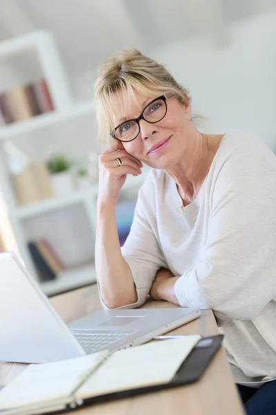 Senior vrouw die op laptopcomputer werkt — Stockfoto