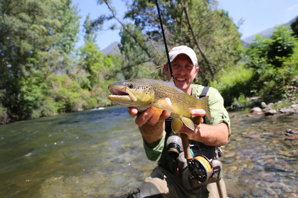 Pêcheur tenant de la truite brune — Photo