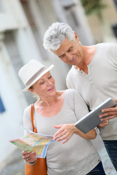 Turistas andando na rua com mapa e tablet — Fotografia de Stock