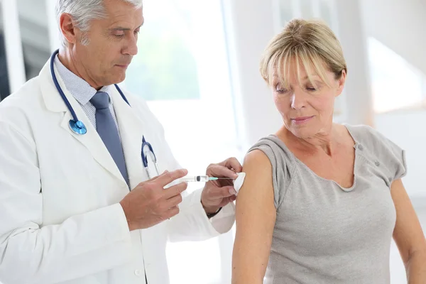 Doctor injecting flu vaccine — Stock Photo, Image