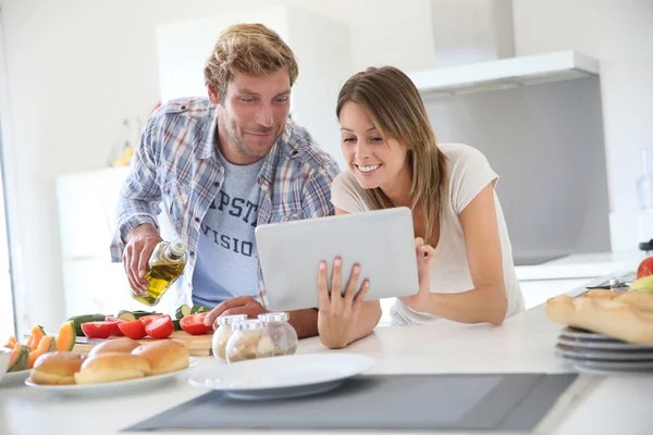 Casal alegre na cozinha cozinhar jantar — Fotografia de Stock