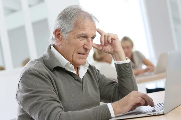 Senior man med bärbar dator — Stockfoto