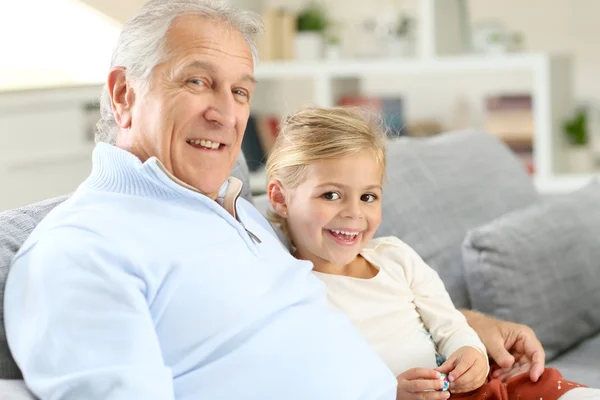 Grandfather with girl sitting in couch — Stock Photo, Image