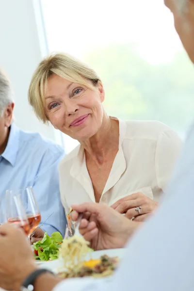 Senior woman sharing lunch with friends — Stock Photo, Image