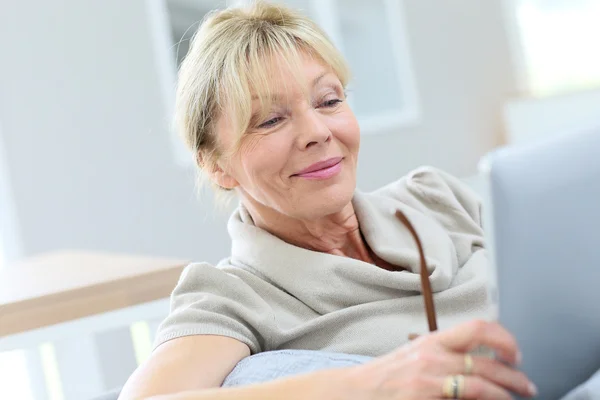 Mulher em óculos usando tablet digital — Fotografia de Stock