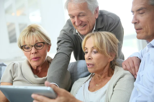 Personnes assises sur un canapé et utilisant une tablette — Photo