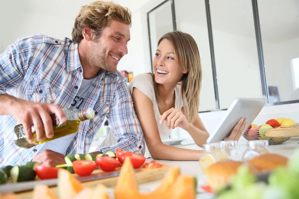 Casal alegre na cozinha cozinhar jantar — Fotografia de Stock