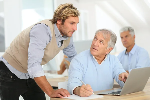 Men attending business class with trainer Stock Photo
