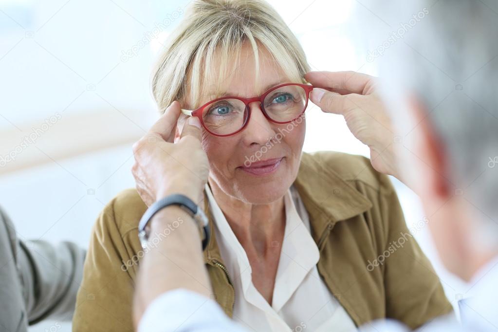 Senior woman trying new eyeglasses on