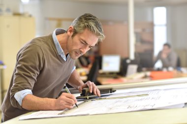 Architect working on drawing table clipart