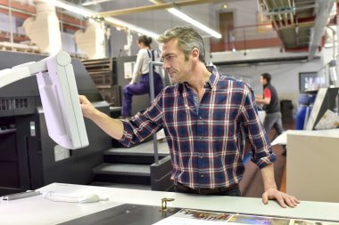 Man working on printing machine clipart