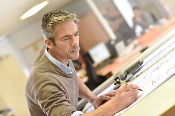 Architect working on drawing table