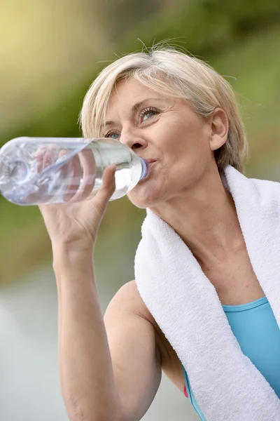 Жінка п'є воду після вправ — стокове фото
