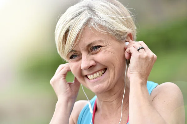 Mujer ajustando auriculares —  Fotos de Stock