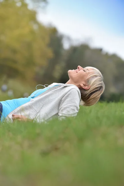 Senior woman relaxing in park — Stock Photo, Image