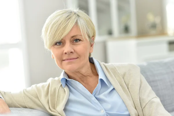 Mujer relaja en el sofá — Stockfoto