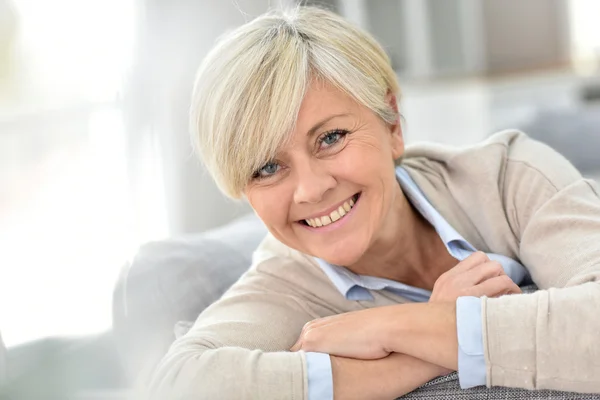 Mujer relaja en el sofá — Stockfoto