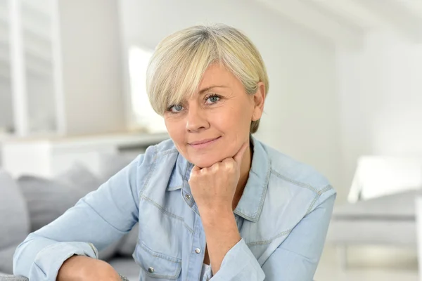 Oudere vrouw zittend op de bank — Stockfoto