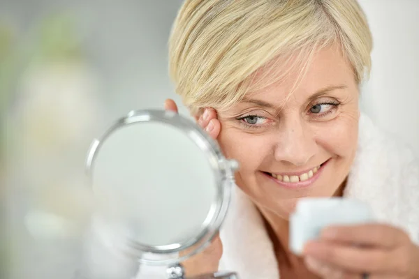 Mujer aplicando loción antienvejecimiento —  Fotos de Stock