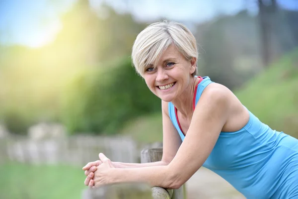 Donna appoggiata alla recinzione — Foto Stock