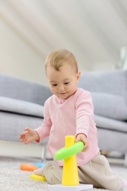 halıda oyuncakla oynayan kız