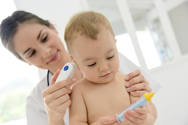 Pediatra tomando a temperatura do bebê — Fotografia de Stock