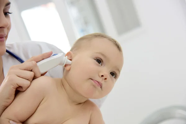 Pediatra biorąc dziecka temperatury — Zdjęcie stockowe