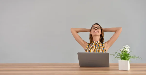 Woman in office stretching arms — Stock Photo, Image