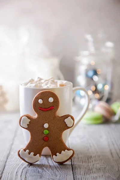 White mag of coffee with marshmallow and gingerbread snowman on a wooden table. Christmas break . — Stock Photo, Image