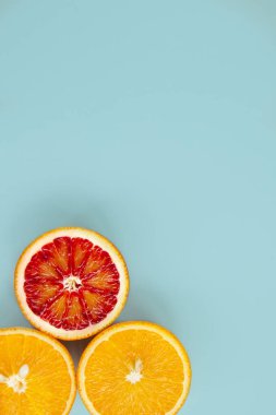 Moda mavisi arka planda üç farklı portakal dilimi. Üst görünüm ve kopyalama alanı