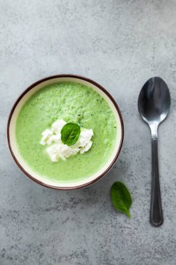 Yeşil kremalı çorba, gri bir masada mavi bir kasede. Yaz yemeği ya da akşam yemeği.