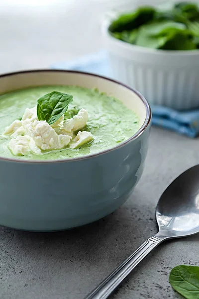 Yeşil kremalı çorba, gri bir masada mavi bir kasede. Yaz yemeği ya da akşam yemeği.