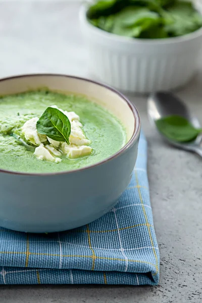Yeşil kremalı çorba, gri bir masada mavi bir kasede. Yaz yemeği ya da akşam yemeği.