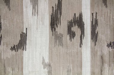 Gri ve beyaz kumaş üzerine nakış işlenmiş soyut kumaş deseni. Arkaplan dokusu tasarım için bir örnektir.