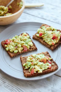 Kahvaltı için avokado ve domatesli vejetaryen yeşil sandviçler.