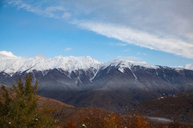 Sonbahar dağları, mavi gökyüzünde karlı bir tepe.