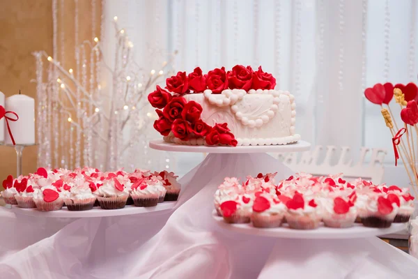 Hermoso pastel de boda y cupcakes en la decoración — Foto de Stock