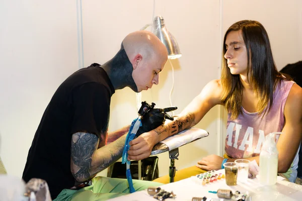 MINSK, BELARUS - SEPTEMBER 19, 2015: Professional tattoo artist doing tattoo on client hand. — ストック写真