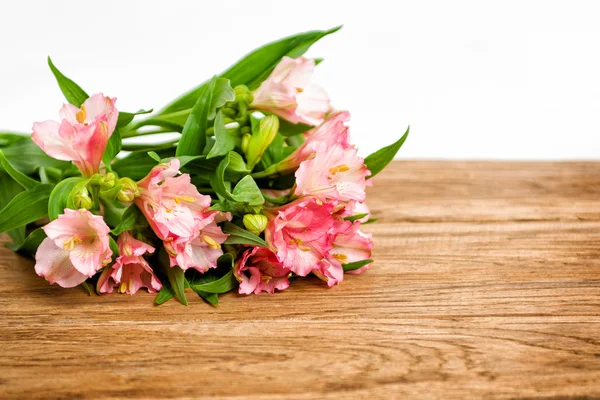 Bukiet różowy Alstremerii na drewnianej tablicy — Zdjęcie stockowe