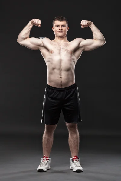 Sportlicher und gesunder Mann isoliert auf schwarzem Hintergrund Stockbild