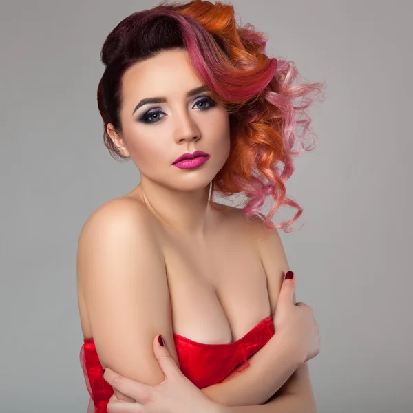 Menina bonita em vestido vermelho com cabelo encaracolado . Imagem De Stock