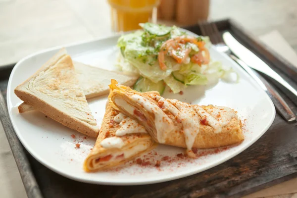 Skrembl espolvoreado con migas de tocino crujiente y mezcla de ensalada de sala — Foto de Stock