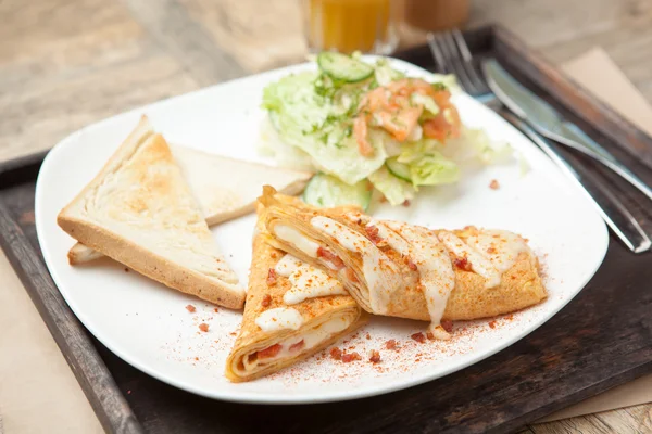 Skrembl espolvoreado con migas de tocino crujiente y mezcla de ensalada de sala — Foto de Stock