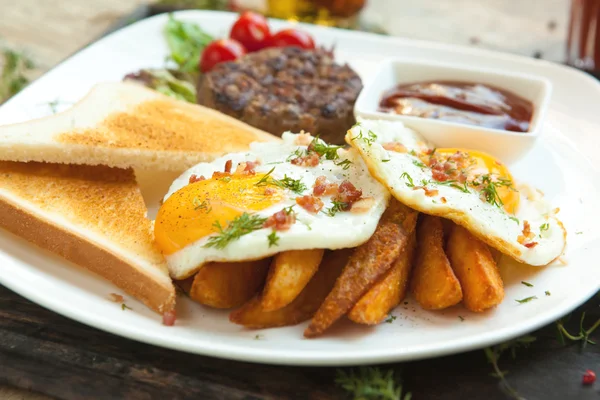 Carne picada na grelha com ovos fritos, crocantes e torradas . Fotos De Bancos De Imagens