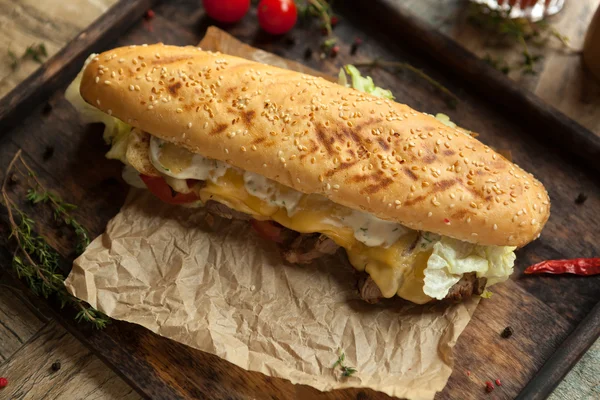 Baguette di grano, filetto di manzo, formaggio reale alla griglia, pomodoro, i — Foto Stock