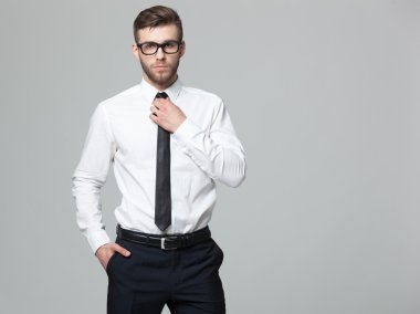 Gri arka planda genç yakışıklı işadamıstüdyo çekim.
